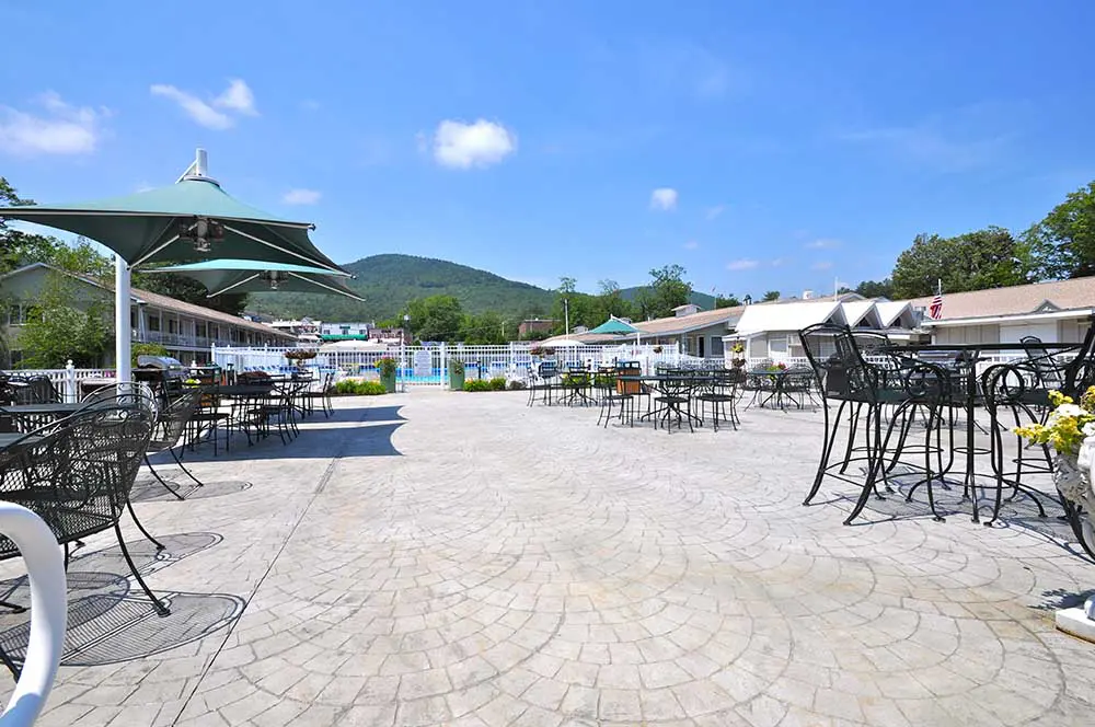 Patio area next to pool with tables and chairs